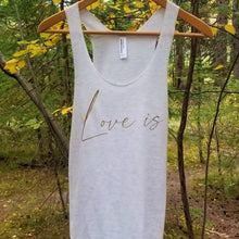 Load image into Gallery viewer, An oatmeal coloured tank top hanging from a branch with the words Love is in gold letters